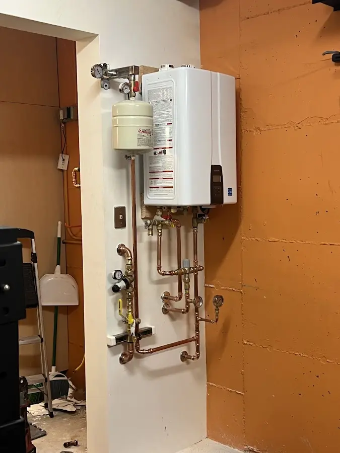 Plumbing technician inspecting water heater connections in Fort Fairfield